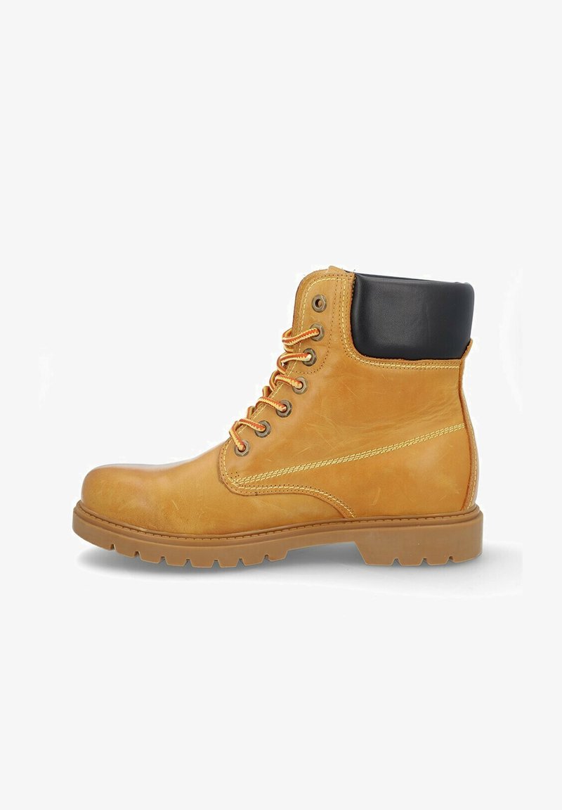 Botín de ante de color marrón con un cuello negro, cordones naranjas y una suela de goma texturizada. Cuenta con ojales metálicos y detalles de costura en contraste.