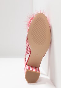 Chaussure à talon bas à motif vichy rouge et blanc avec garniture en plumes, vue de la semelle, taille 37 marquée sur la semelle beige.