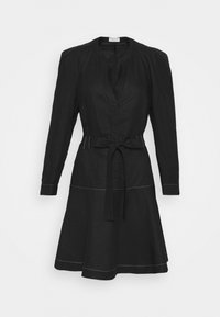 Musta pellavamekko pitkällä hihalla, nappikiinnitys edessä ja vyö vyötäröllä. Mekossa on valkoista ommelta helman ja hihansuiden ympärillä sekä levenevä hame.