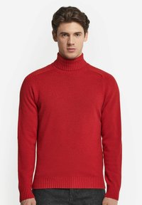 Röd stickad skjorttröja med ribbad krage och fåll, som har en slät yta och långa ärmar. Klassisk passform.