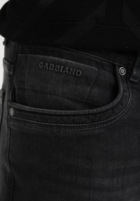 Mustad denim püksid kergelt kulunud nägelustega, millel on Gabbiano logo vööl ja klassikaline viie tasku disain metallist nupukestega.