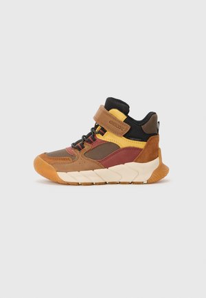 Børne høj-top sneaker med brune, gule og rustfarvede paneler, sort polstret krave, hvid chunky sål og velcrorem lukning.