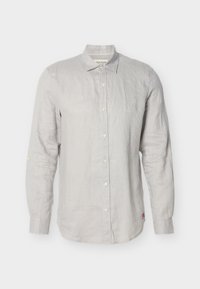 Ανοιχτό γκρι μακρυμάνικο πουκάμισο με κουμπιά, γιακά, κουμπί σε κάθε μανσέτα και μικρό κόκκινο λογότυπο κοντά στο κάτω μέρος, σε λευκό φόντο.