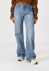 Svetlo modri jeans z ravnim krojem. Ima sprednje žepke, diskretno šivanje in sproščen kroj. Ujemite jih z nevtralnimi supergami.