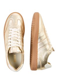 Gouden metallic sneakers met witte veters, een bruine rubberen zool en witte accenten op de hiel. Een gladde textuur met subtiele stikdetails.
