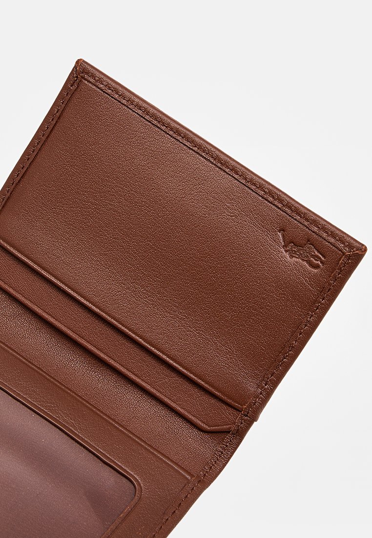 Braune Ledergeldbörse mit strukturierter Oberfläche, mehreren Kartenfächern und einem transparenten Ausweisfenster. Kleines geprägtes Designdetail auf der Oberfläche.