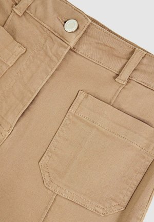 Beige cargo pants with a front pocket, button closure, and belt loops. The fabric is smooth with a subtle texture and reinforced stitching.