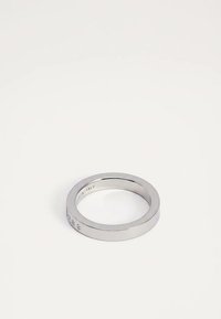 Απλό ασημένιο μεταλλικό δαχτυλίδι με λεία, γυαλισμένη επιφάνεια και διακριτικές χαράξεις στις εξωτερικές και εσωτερικές άκρες, τοποθετημένο σε λευκό φόντο.