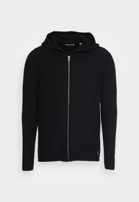 Svart zip-up hoodie tillverkad av texturerat material. Har en fodrad huva, ribbad design och långa ärmar med åtsittande muddar.