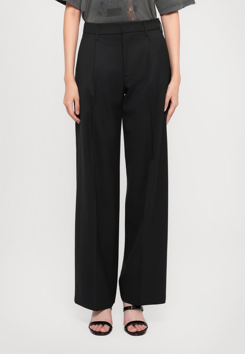 Black wide-leg trousers with a tailored design, featuring front pleats, a smooth texture, and a high waistband. Paired with black sandals.