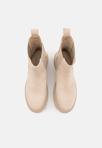 Beige Knöchelstiefel aus glattem Wildleder mit elastischen Seitenpaneelen und Ziehhilfen. Dicke Gummisohle mit dezentem Profil.