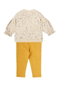 Top de algodón con base beige, patrón de estrellas y planetas; mangas abullonadas. Leggings a juego en mostaza con un acabado texturizado.