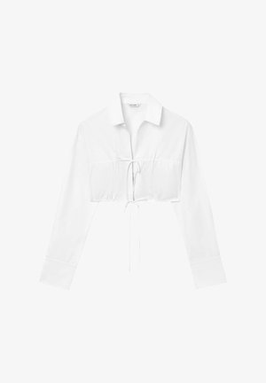 Blouse blanche cropped à manches longues, avec col et détail à cordon à la taille. Fabriquée en tissu lisse, elle présente des coutures froncées.