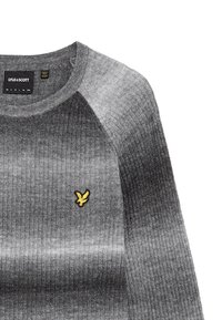 Grauer Strickpullover mit gerippter Textur, Farbverlauf, runder Halslinie und einem kleinen gelben gestickten Logo auf der Brust.