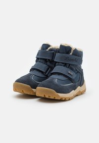 Botas infantiles de color azul marino, hechas de ante y malla, con doble cinta de Velcro, forradas con pelo beige y suela de goma con tracción.