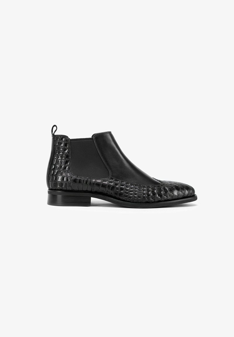 Bottines Chelsea en cuir noir avec un motif crocodile texturé, des panneaux latéraux élastiques et un petit talon empilé pour plus de stabilité.
