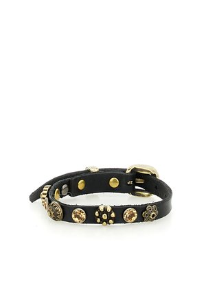 Bracciale in pelle nera con borchie dorate e gemme color ambra, con una piccola fibbia su sfondo bianco.