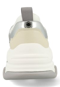 Der Schuh verfügt über ein Obermaterial aus weißem Mesh mit grauen und silbernen Akzenten, einer abgerundeten Zehenpartie, einer gepolsterten Ferse und einem auffälligen Logo-Detail am Fersenelement.