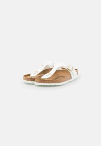 Witte flip-flopsandalen met een kurken voetbed, rubberen zool en gouden hardwareaccenten. Beschikt over een teenslipperontwerp met een gladde textuur.