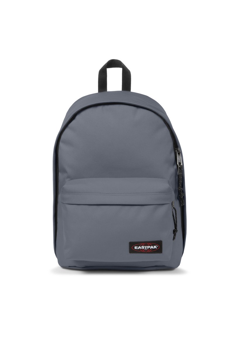 Zaino grigio realizzato in tessuto resistente, dotato di un grande scomparto principale, tasca frontale con zip e maniglia superiore per il trasporto. Presenti dettagli neri.