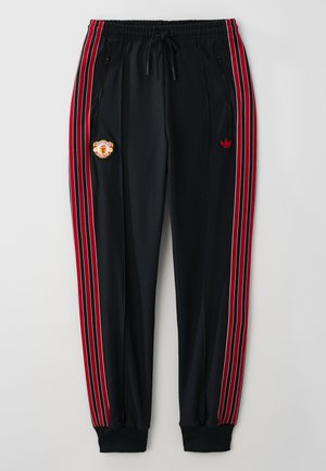 Pantaloni atletici negri cu dungi laterale roșii și albe, buzunare cu fermoar, manșete ribbate și un logo brodat pe coapsa stângă.