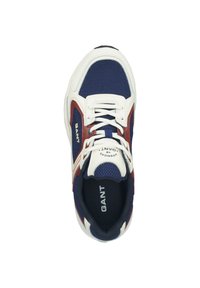 Marineblaue und weiße Sneaker aus Meshgewebe, mit Gummisohle und roten Akzenten. Verfügt über Schnürsenkel und Branding auf der Zunge und der Seite.