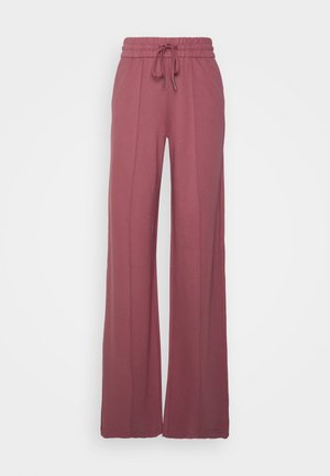 Pantalon taille haute rose poudré à jambes larges avec une taille élastique et un cordon de serrage à l’avant, présentant des détails de coutures verticales le long des jambes.