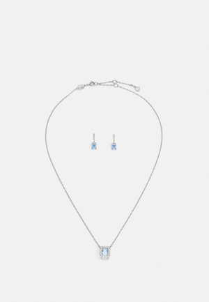 Silber Schmuckset mit einer Anhänger-Halskette, die einen rechteckigen hellblauen Stein und passende Ohrstecker umfasst, beide mit filigranen Details.