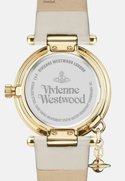 Horloge van goudkleurig roestvrij staal met een ronde kast, witte wijzerplaat en gouden accenten, voorzien van een lichtgekleurde leren band en charm-detail.