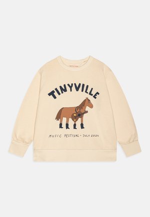 Sweat-shirt beige avec un cheval dessin animé portant des bottes et tenant une guitare, texte "TINYVILLE" au-dessus et "Music Festival - juillet 2024" en dessous.