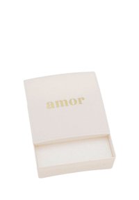 Liten vit öppen låda med guldtexten "amor" på locket, som visar ett tomt inre med vit vaddering inuti.