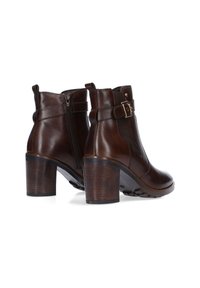 Stivali ankle in pelle marrone con cerniera laterale, tacco a blocco e cinghia decorativa con fibbia dorata. Finitura liscia e design a punta tonda.