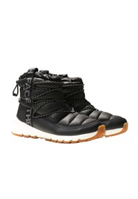 Black quilted ankle boots with a textured upper, elastic laces, and a white midsole. The sole features a gum rubber tread pattern.