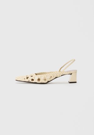 Woven beige slingback shoe with a pointed toe and a low block heel. The upper features cut-out patterns and a smooth finish.