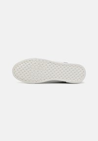 White sneaker sole featuring a geometric texture. The design emphasizes a flat profile with a slightly raised edge.