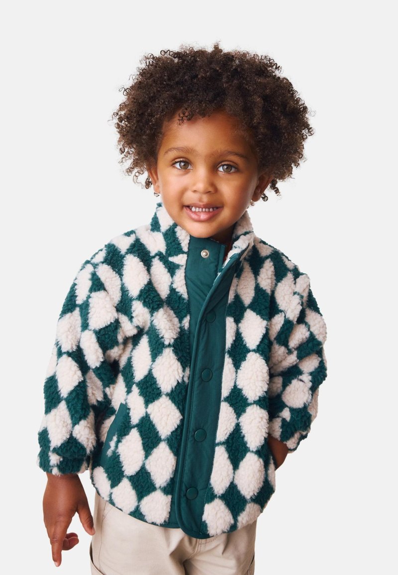 Giacca in pile con motivo a rombi verde e bianco, bottoni a pressione, collo con colletto e tessuto strutturato. Adatta ai bambini.