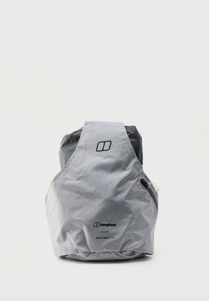 Mochila Berghaus Fast Hike 15 de color gris claro con patrón de rejilla sutil, logo frontal y bolsillo lateral con cremallera, colocada en posición vertical sobre un fondo blanco.