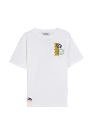 Camiseta blanca de manga corta con texto "SCALPERS" y gráfico de calavera en la parte superior izquierda, y pequeño diseño de estallido solar azul y naranja cerca del dobladillo inferior.