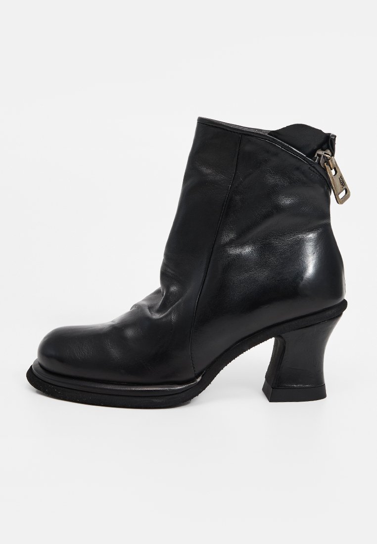 Czarny skórzany botek za kostkę z zaokrąglonym noskiem, średniej wysokości obcasem w kształcie bloku oraz zewnętrznym zamkiem błyskawicznym z metalowym uchwytem. Gładka tekstura.