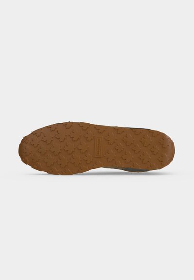 Semelle de chaussure en caoutchouc marron avec un motif de feuille d'érable et un logo rectangulaire de la marque au centre.