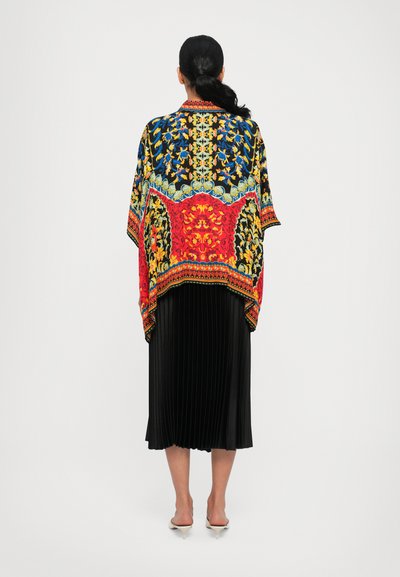 Multicolored shawl with intricate floral and geometric patterns in red, blue, yellow, and black; features a loose, flowing design.