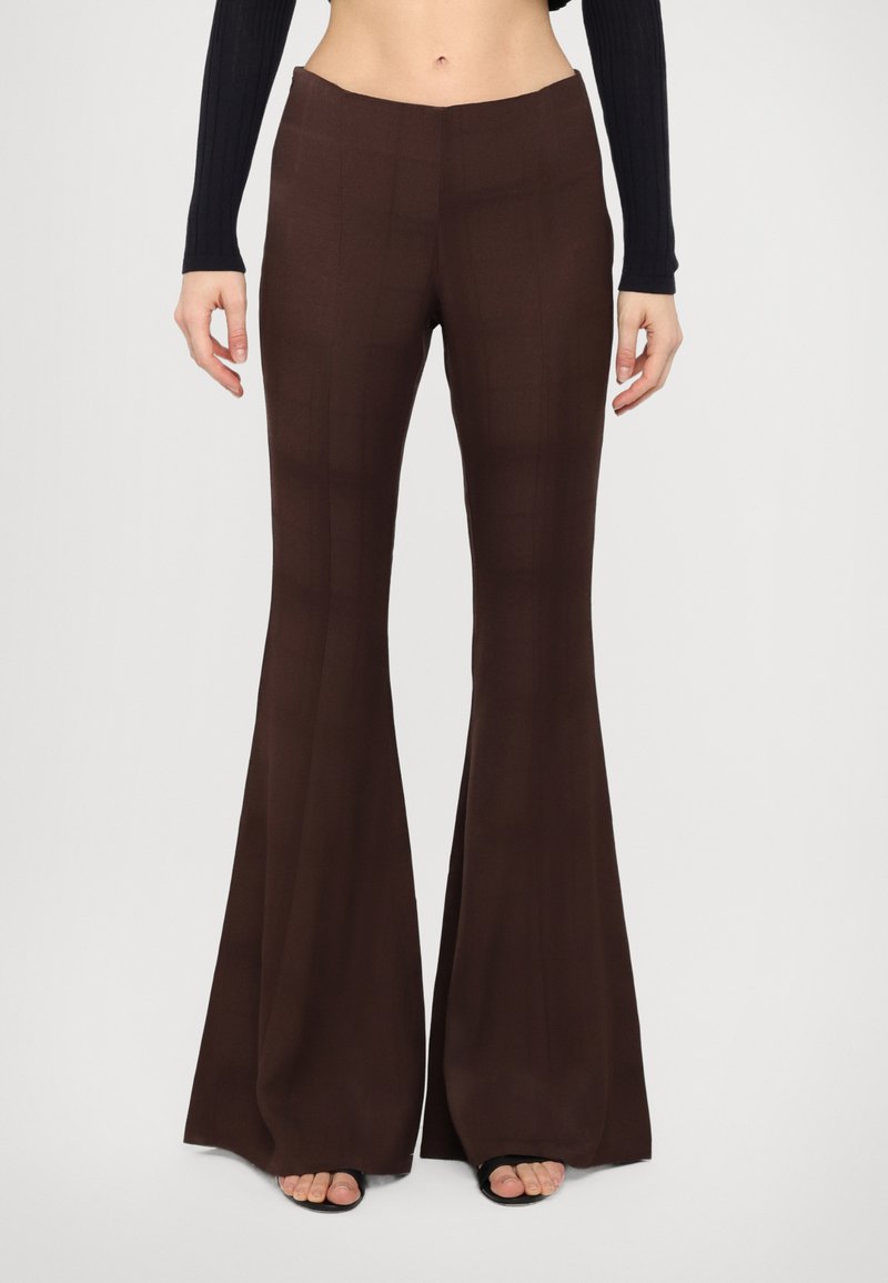Brown flared trousers with a smooth texture, featuring a subtle grid pattern. High-waisted design with a minimalist waistband.