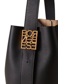 Black leather tote bag featuring a textured surface and a gold metal logo tag displaying "BORNOSE." Includes sturdy black handles.