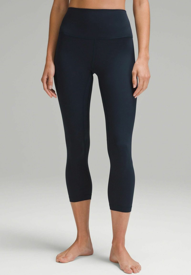 Svarta capril leggings med hög midja, tillverkade av ett slätt, elastiskt tyg. Har en figurnära design och är av ankellängd.