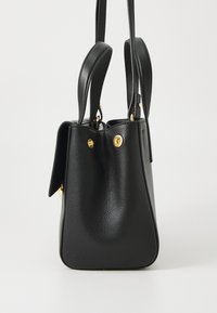 Sac à main en cuir noir avec une finition texturée, doté de doubles poignées et d'accents en métal doré. Forme effilée avec une silhouette lisse.