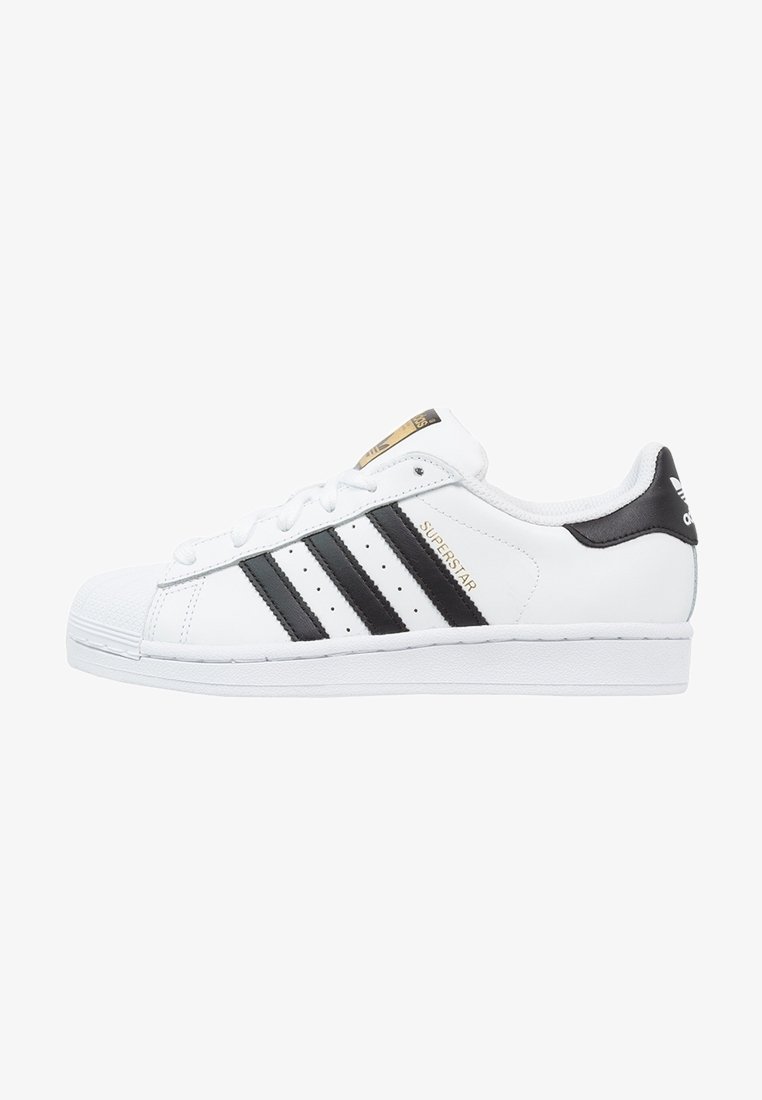 Zapatilla Adidas Superstar blanca con rayas negras, texto dorado "Superstar" y diseño de punta de concha, vista lateral sobre fondo blanco.