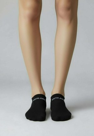 Schwarze Knöchelsocken mit einem gerippten Bund und weißer Aufschrift "SIXTH JUNE". Glatte Textur, minimalistisches Design, eng anliegende Form.