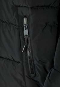 Jachetă puffer neagră dintr-un material cu textură matlasată; dispune de o parte cu un buzunar cu fermoar, având un capac de fermoar negru și un finisaj texturat pentru prindere.