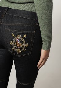 Černé džíny z denimu s detailním vyšíváním koně a jezdce na zadní kapse, s kontrastním šitím a slim fit střihem.