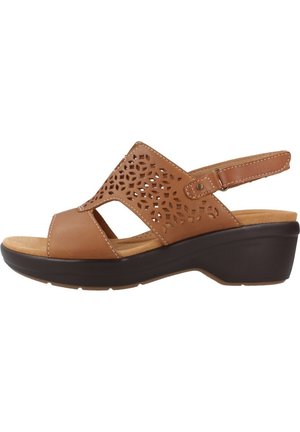 Brown leather wedge sandal with cut-out pattern and adjustable slingback strap. Features a cushioned insole and textured outsole.